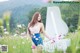 A woman standing in a field of flowers next to a piano.