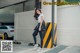 A woman leaning against a wall in a parking lot.