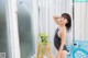 A woman in a bathing suit standing in front of a shower.