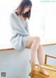 A woman sitting on top of a wooden chair.