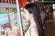 A woman standing in front of a vending machine.